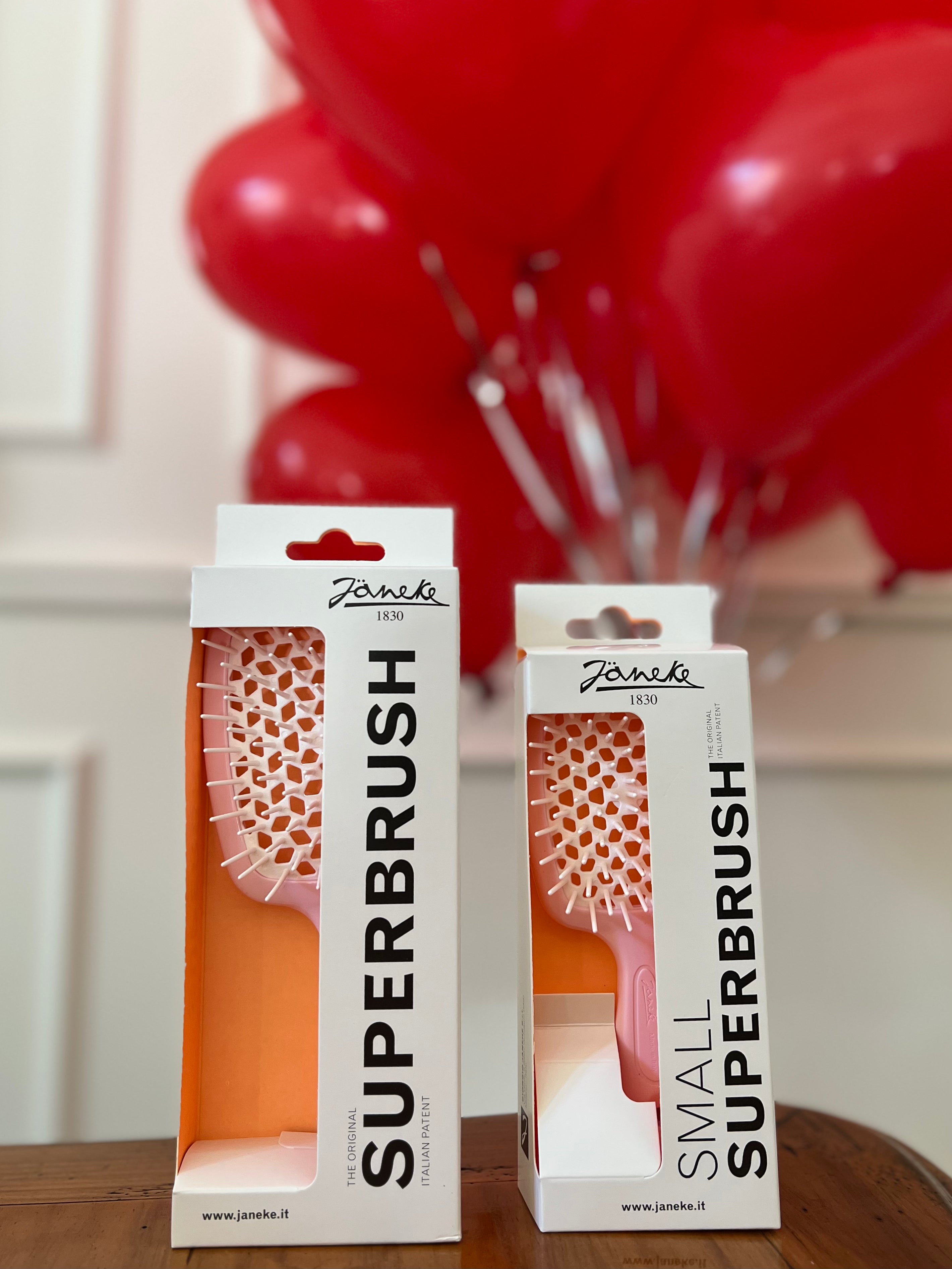 Two boxes of Janeko Superbrushes with red balloons in the background
